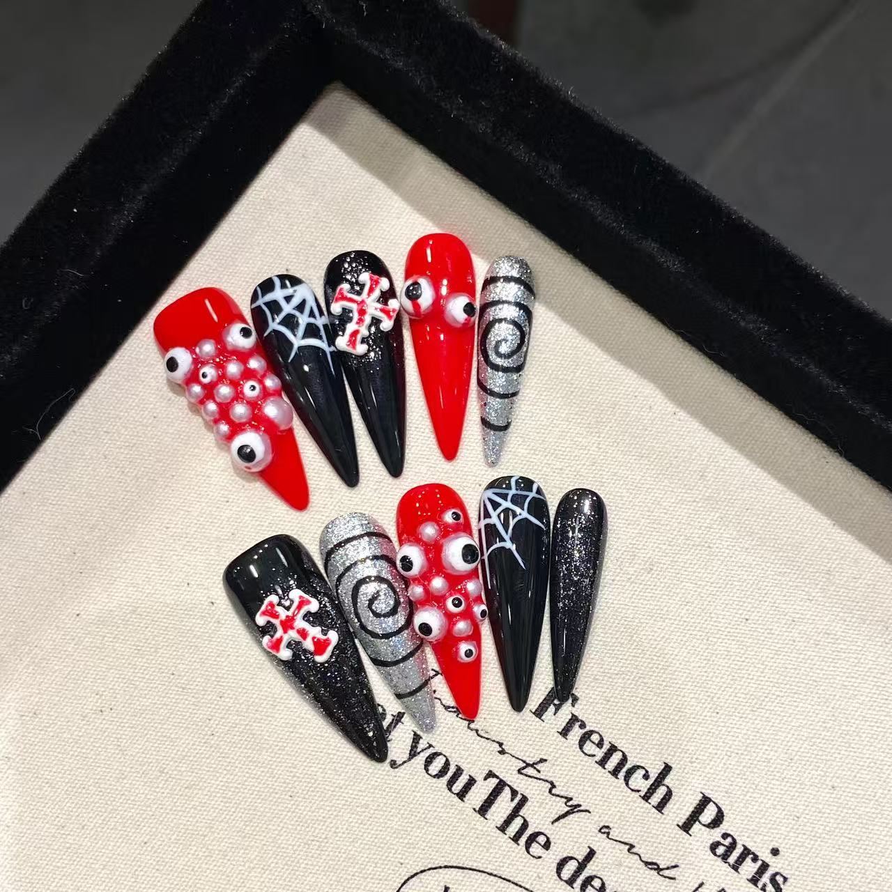 Gothic horror press-on nails with googly eyes, spiderwebs and crossbones in red black silver